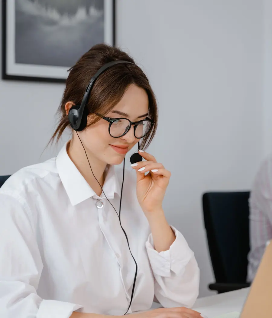Analista de suporte com headset atendendo um chamado no notebook